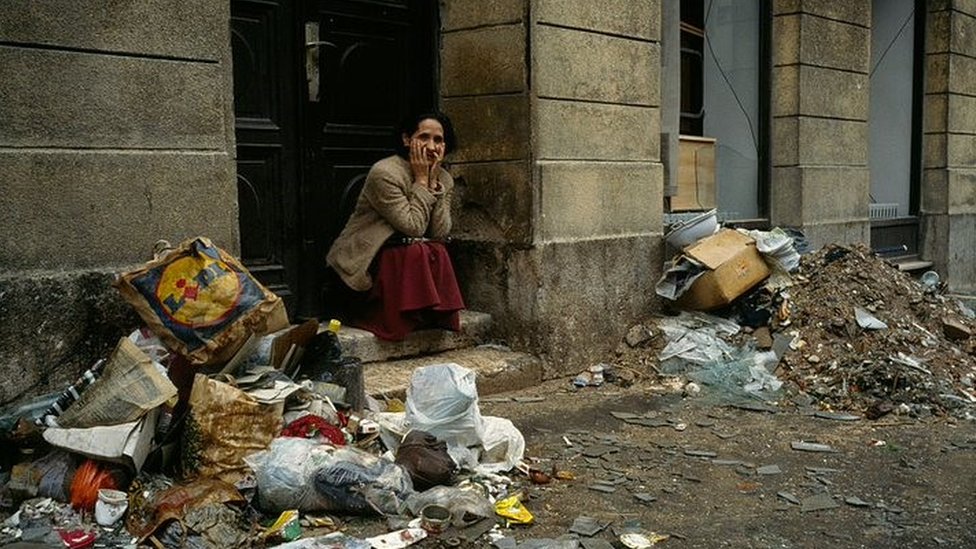 Saraybosna'da çöpler arasında oturan bir kadın.