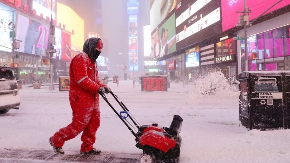 A worker clears snow in Times Square