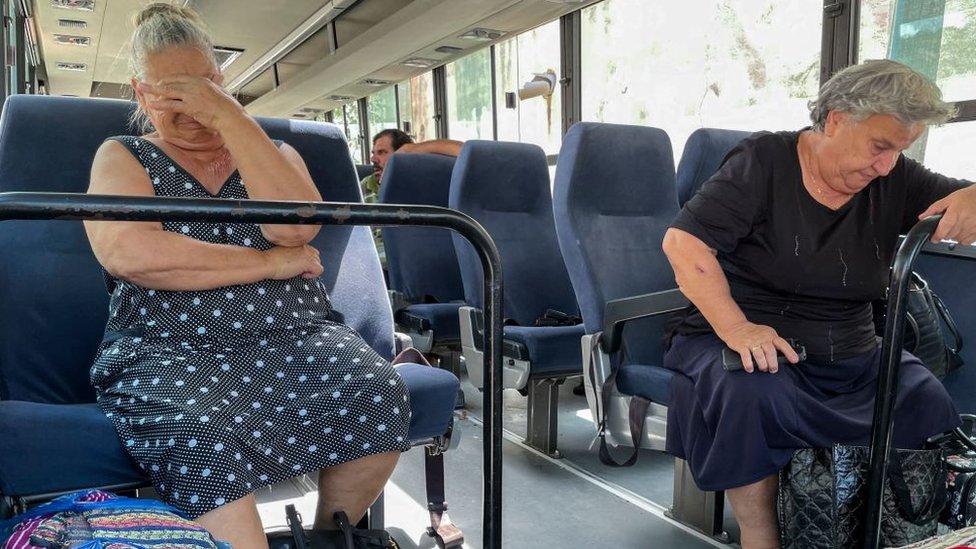 Two people sit on a bus.