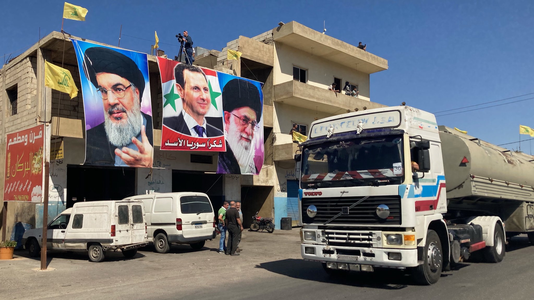 Posters of Hezbollah leader Hassan Nasrallah, Syrian President Bashar al-Assad and Iranian Supreme Leader Ali Khamenei on a building in al-Ain, as lorries bring Iranian fuel from Syria into Lebanon (16 September 2021)