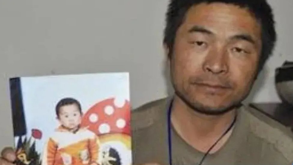 Guo Gangtang e uma foto de seu filho desaparecido