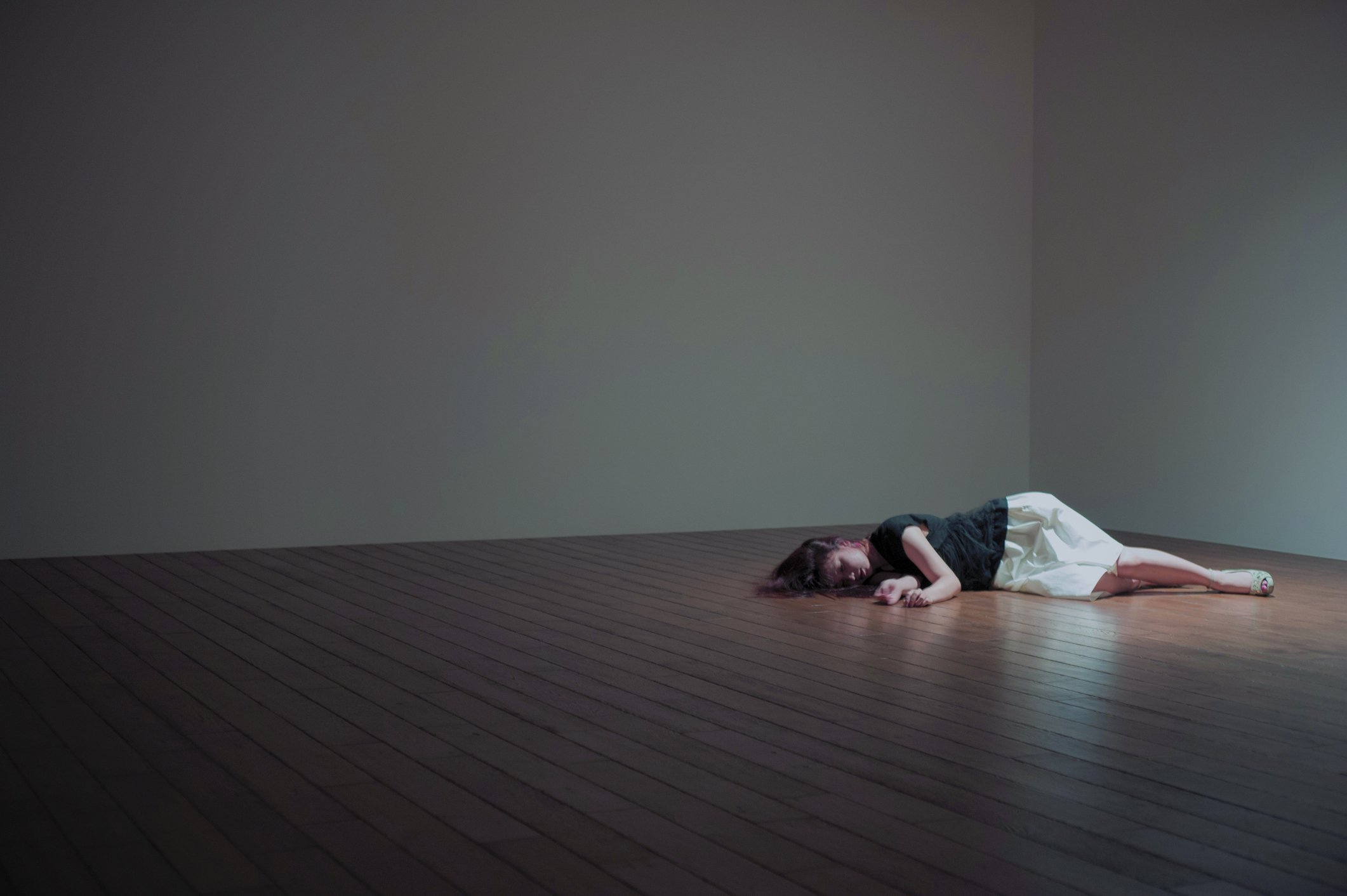 Un mujer yace en el piso de una habitación vacía