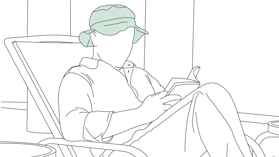 Hombre sentado leyendo.