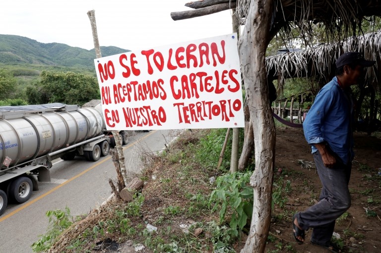 Табличка гласит: «Мы не терпим и не принимаем наркокартели на нашей территории» на контрольно-пропускном пункте в Мексике