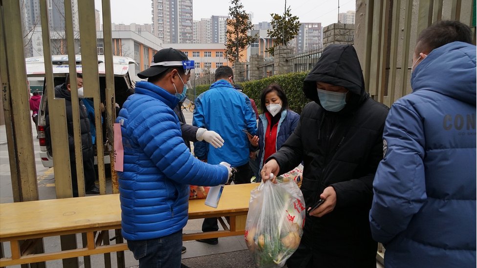 Residents line up to buy vegetables in a gated community in Xi 'an, Shaanxi Province, China, On December 31, 2021. It was the ninth day that communities (villages) and units in xi 'an were under lockdown.