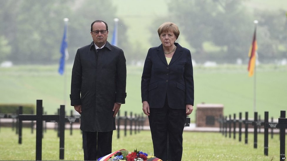 French President Francois Hollande and German Chancellor Angela Merkel pay their respects after laying a wreath.
