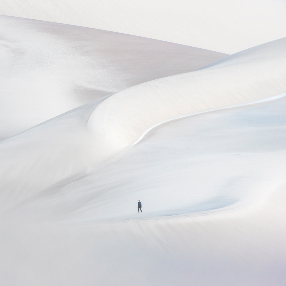 Usamljeni šetač na beloj peščanoj dini u La Puni, Argentina.