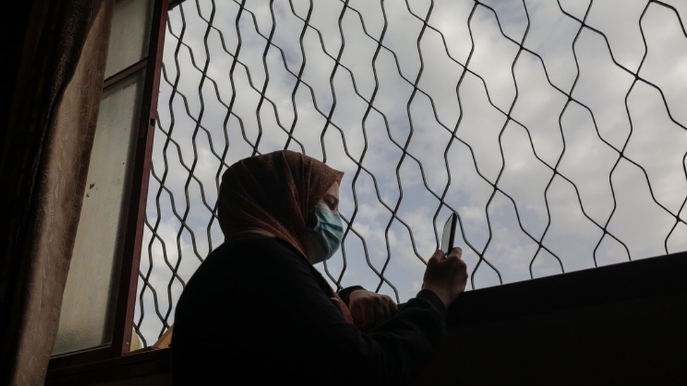 امرأة ترتدي كمامة في غزة
