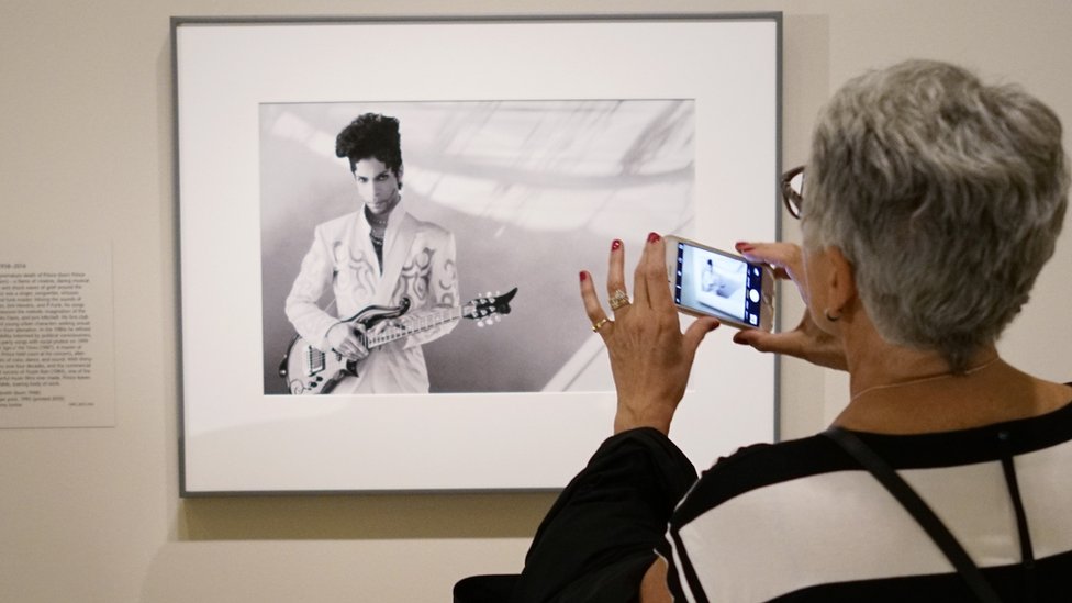 Una visitante mira una fotografía del músico Prince tomada por Lynn Goldsmith en 1993 en la Galería Nacional de Retratos del Smithsonians el 22 de abril de 2016, en Washington DC.