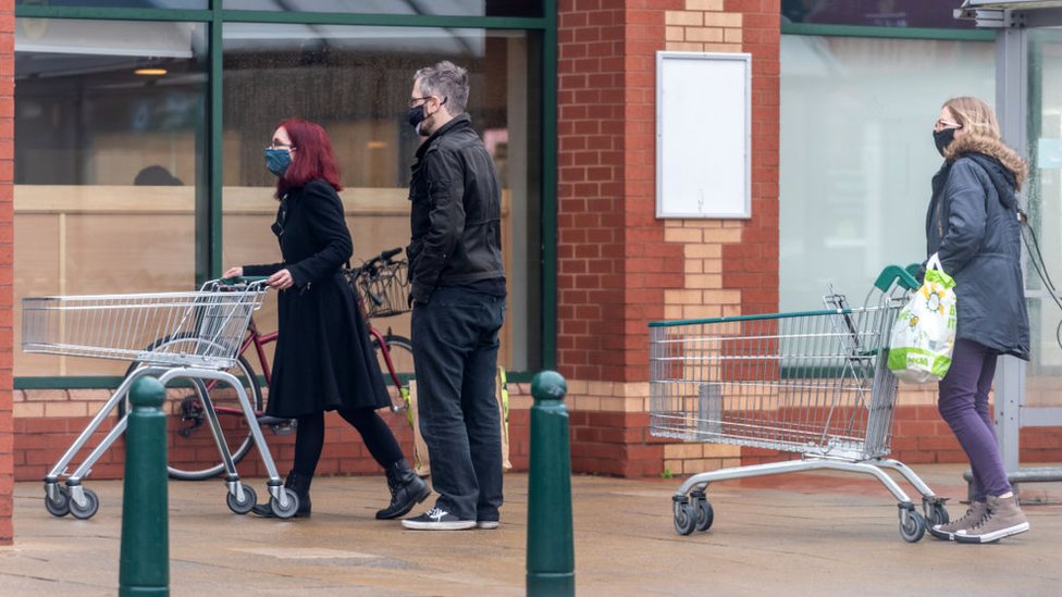 Shoppers queueing outside a Morrisons store