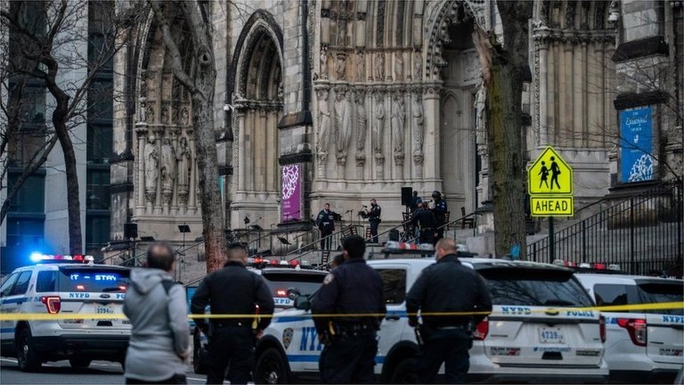 Офицеры стоят у собора Святого Иоанна Богослова на Манхэттене после того, как вооруженный преступник открыл огонь