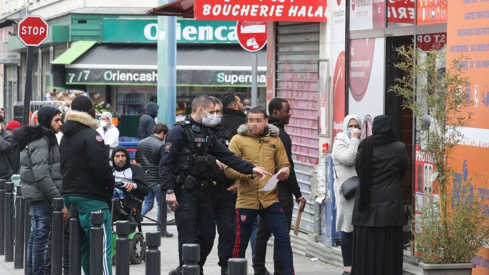 Oficiales de la policía francesa controlando las autorizaciones de salidas de personas el 2 de abril de 2020 en Saint-Denis, en las afueras de París.