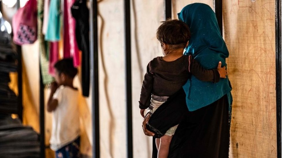 Сара аль-Абдулла несет сироту в лагере в северной сирийской деревне Айн Исса, 26 сентября 2019 года.