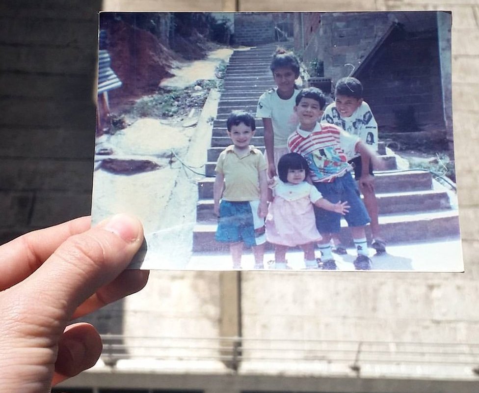 Хосе держит фотографию себя в молодости со своими кузинами и племянницей в Нино Хесус в 90-е