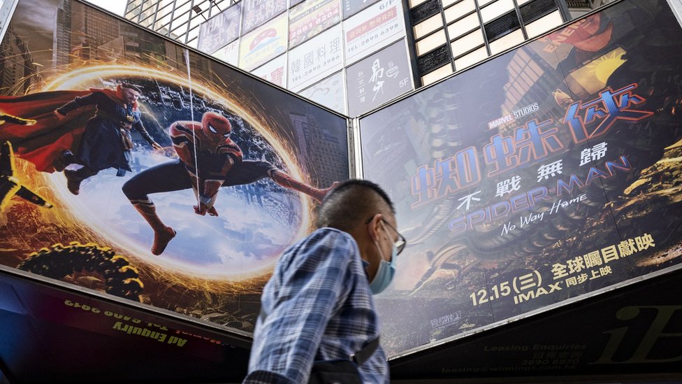 A pedestrian walks past an advertisement billboard from Marvel comics character Spider-Man "No Way Home movie, co-produced by Columbia Pictures and distributed by distributed by Sony Pictures, is being displayed above him in Hong Kong.
