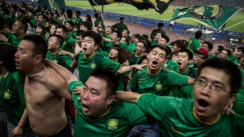 中超比賽中，北京國安球迷背對著球場載歌載舞。