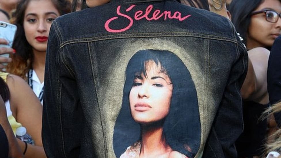 Una mujer usa una chaqueta con la imagen de Selena en la espalda.