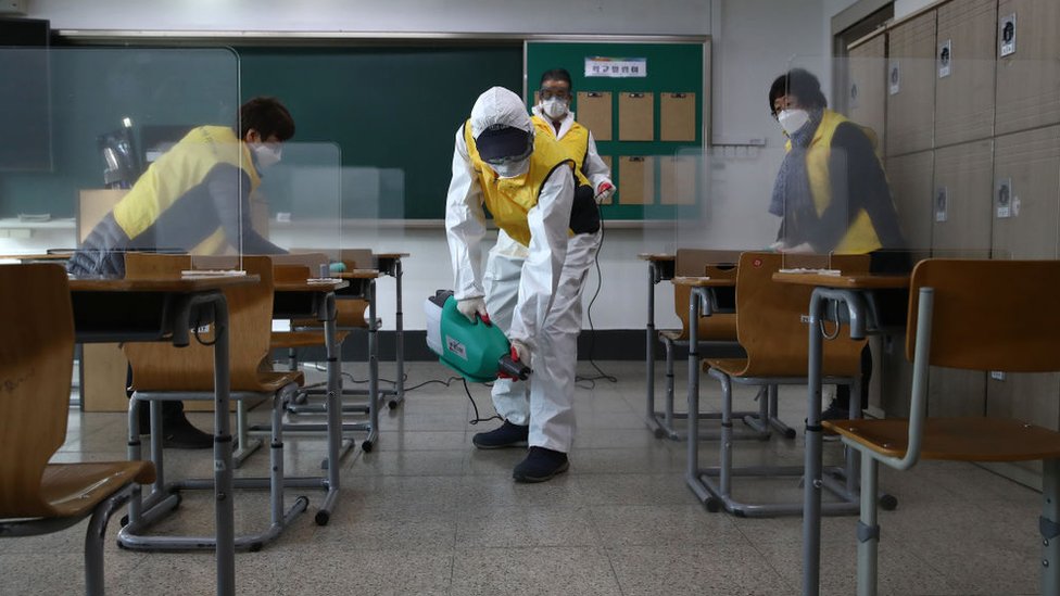Workers disinfect a classroom in Seoul to prevent the spread of the coronavirus ahead of the exams