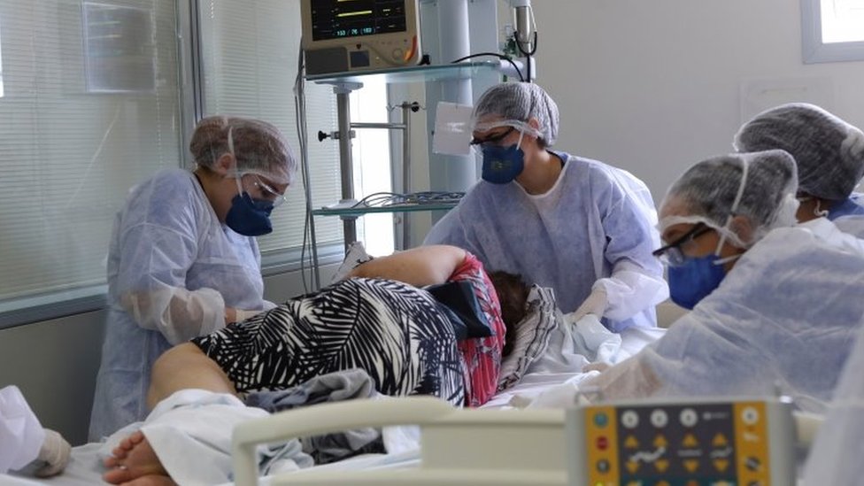 Equipe médica colocando paciente em leito de UTI em SP;
