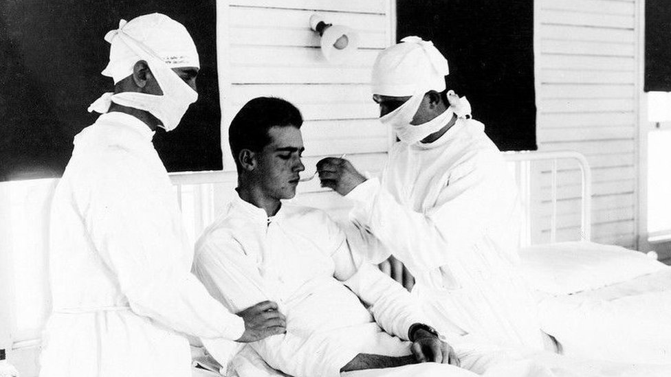 Os médicos tratam um paciente com gripe em Nova Orleans, nos Estados Unidos, em 1918