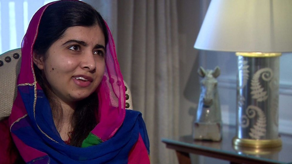 Com véu, Malala sorri enquanto fala em entrevista