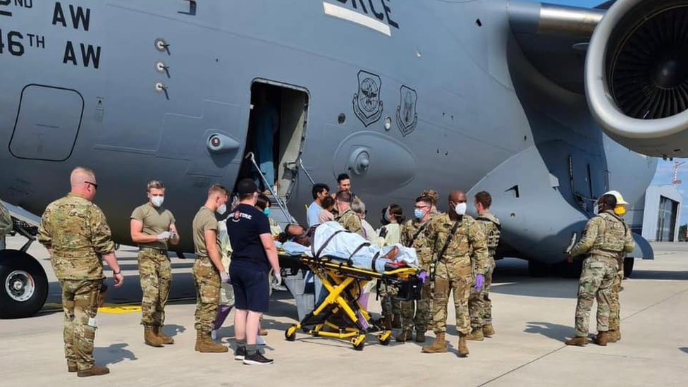 Las fuerzas estadounidenses llevan a una madre y un bebé recién nacido para recibir atención médica después de que las mujeres dieron a luz en un vuelo de evacuación desde Afganistán.