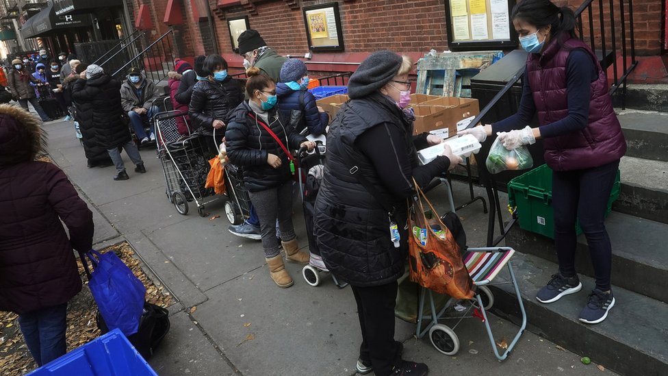 Люди ждут в очереди в Food Pantry Св. Клемента за едой во время пандемии коронавирусной болезни (COVID-19) в районе Манхэттена города Нью-Йорк, штат Нью-Йорк, США, 11 декабря 2020 г.