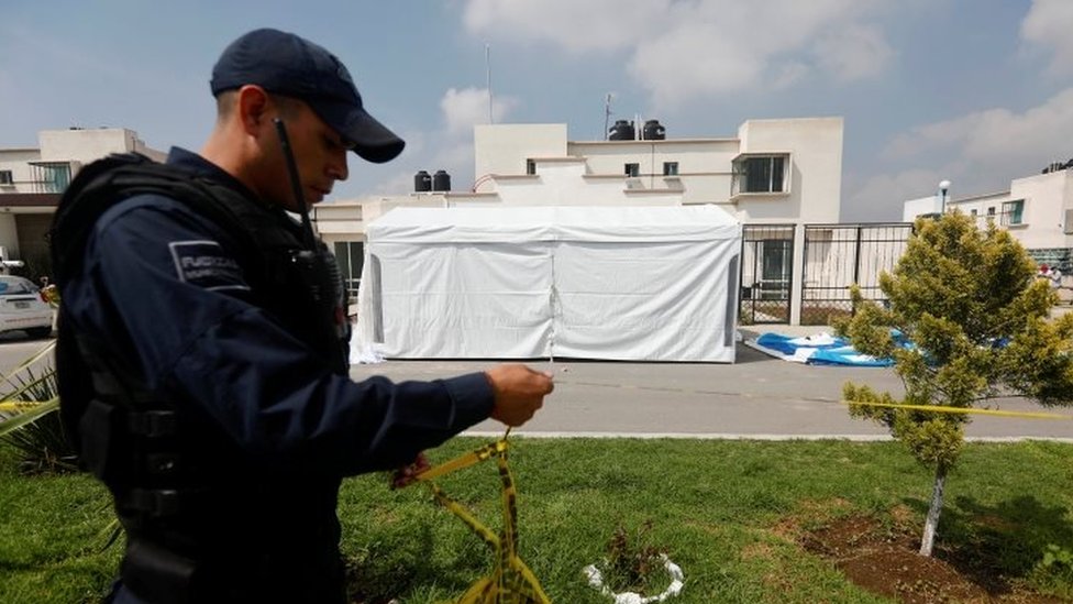 La masacre ocurrió dentro de una carpa en la que se desarrollaba una fiesta infantil. Un policía mira la carpa donde ocurrió una masacre.