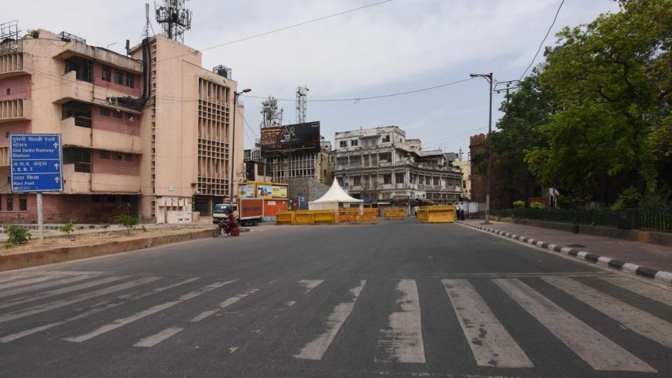 Пустой участок дороги и баррикады полиции Дели для проверки пассажиров во время блокировки у ворот Дели 16 апреля 2020 года в Нью-Дели, Индия.