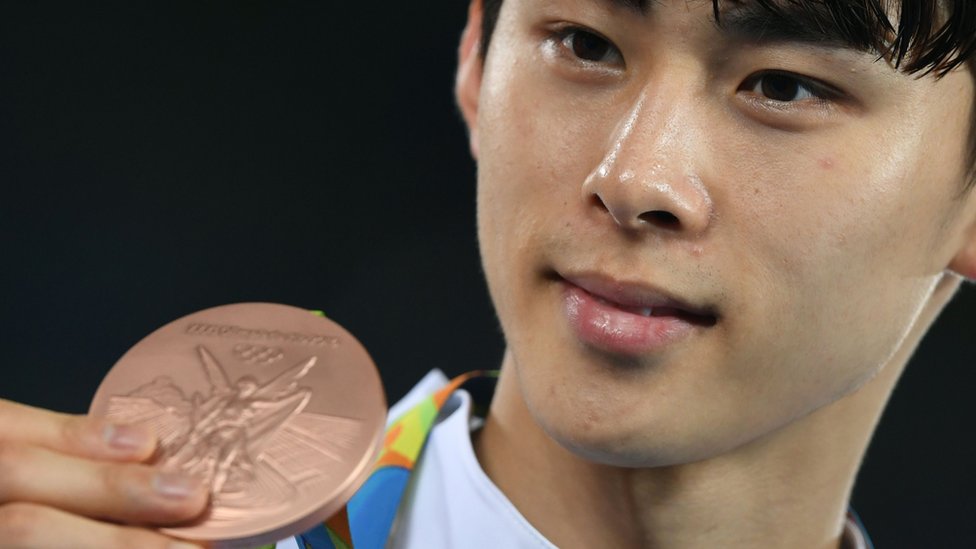 Ким Соху из Южной Кореи позирует со своей бронзовой медалью после мужского тхэквондо
