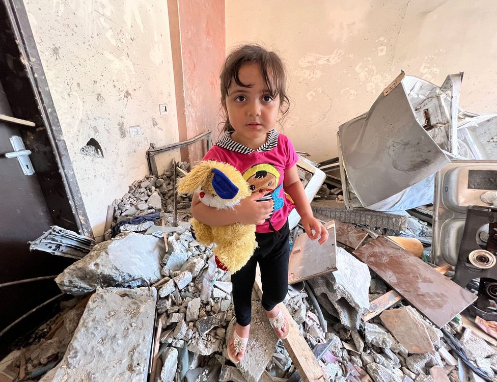 Tuta, la nieta de Samir con su peluche, en los restos de lo que fuera su casa.
