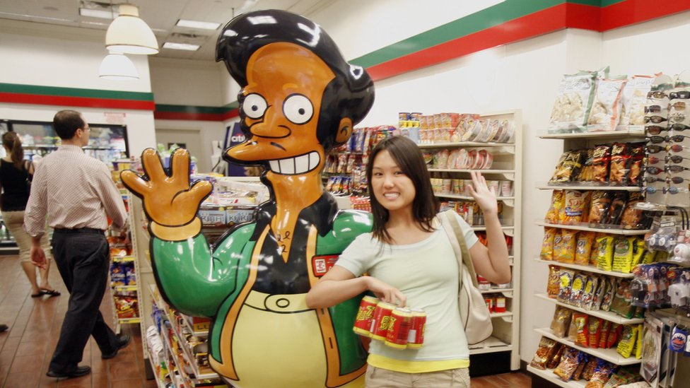 Una mujer posa con un muñeo de Apu.