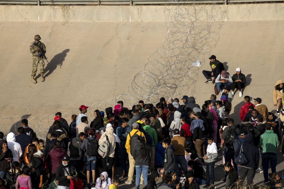 Migrantes ante la alambrada colocada por la Guardia Nacional de Texas en El Paso, Estados Unidos, el 20 de diciembre de 2022.