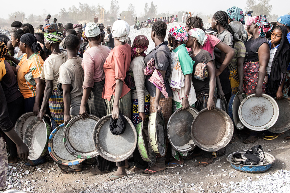 نساء ينتظرن في طابور طويل للحصول على أجورهن نظير العمل في منجم للجرانيت وسط واغادوغو في بوركينا فاسو.