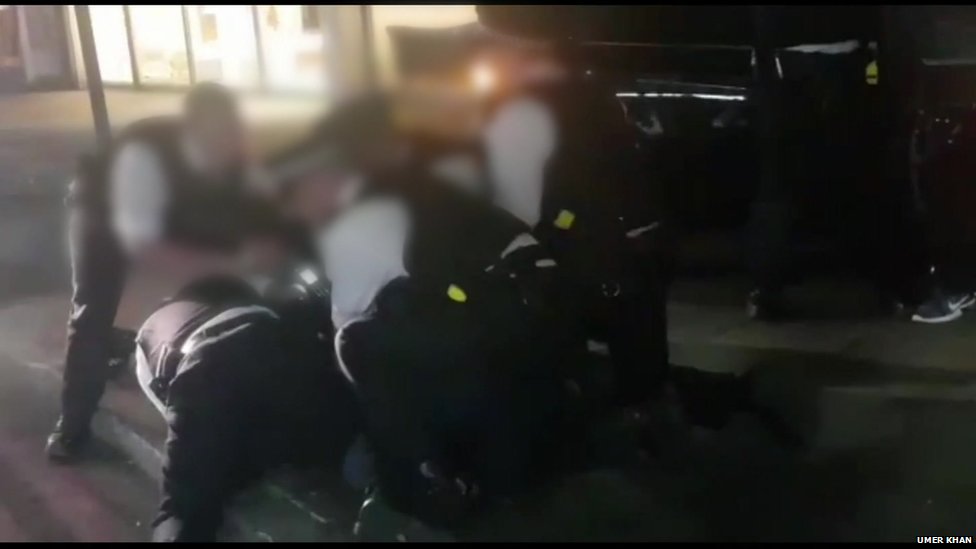 Кадр из видеозаписи с мобильного телефона, на которой полицейские задерживают кого-то во время ареста,