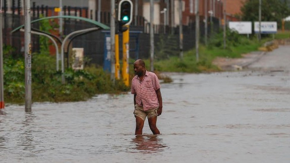 Un hombre camina en una calle inundada
