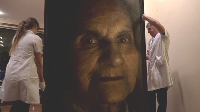 A painting of an old woman's face being moved