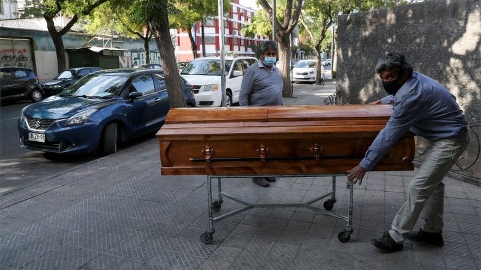 Funeral home workers move a casket outside a morgue at a hospital area, during the coronavirus disease (COVID-19) pandemic, in Santiago, Chile April 8, 2021