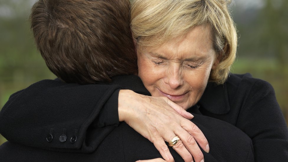 Mujer dando un abrazo con cara de dolor