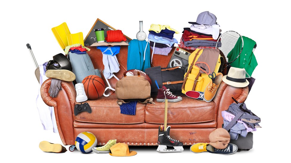 Un sofá lleno de objetos dispares.