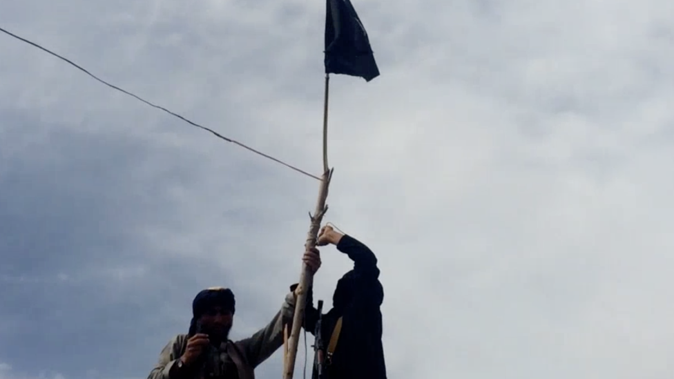 Скриншот видео ИГ, на котором двое мужчин поднимают черный флаг