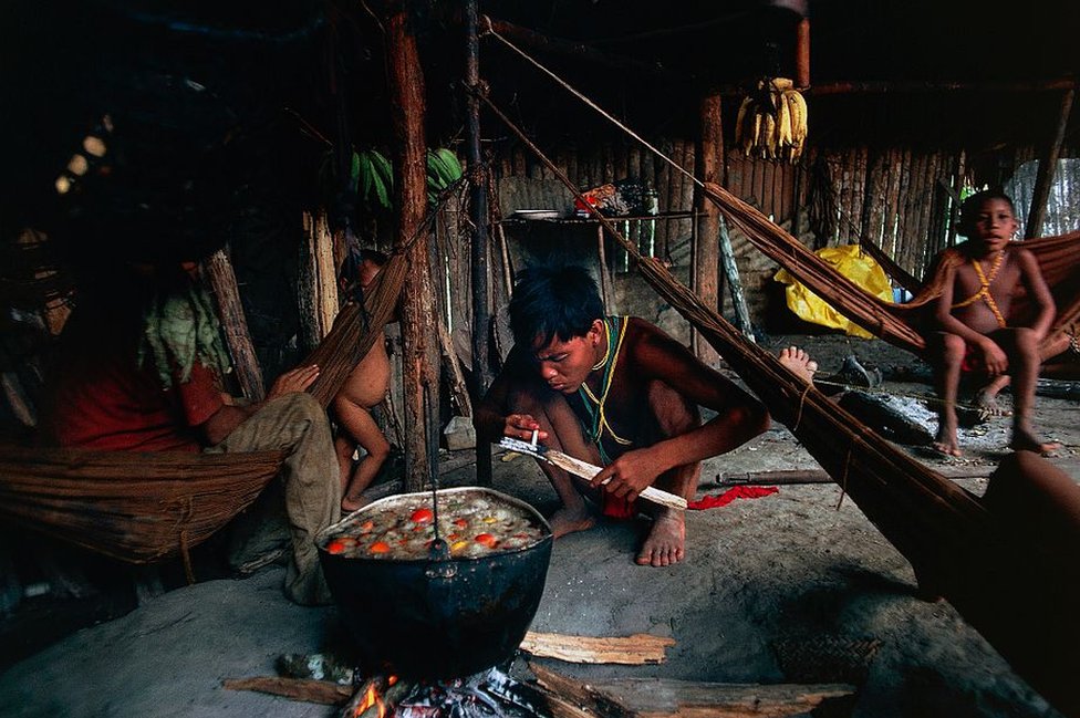 Una familia yanomani dentro de su choza en el Amazonas venezolano.