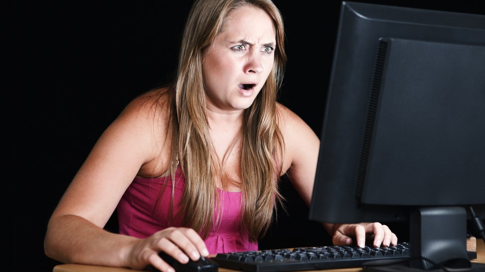 Mujer mirando porno en la pantallas sorprendida.