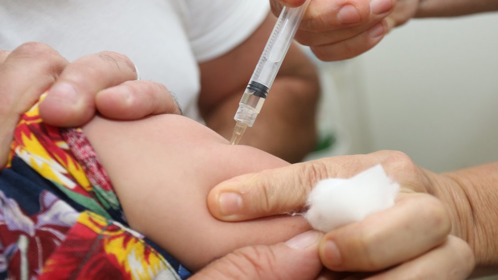 Vacina sendo aplicada em braço de criança