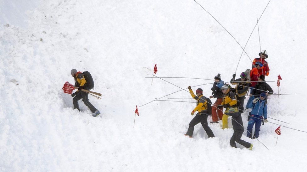 Спасательные силы и вертолеты ищут пропавших без вести после того, как лавина прокатилась по лыжной трассе в центральном городе Андерматт в кантоне Ури, Швейцария