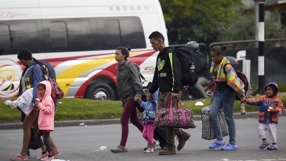 Migrantes venezolanos salen de una terminal de buses hacia un campamento improvisado en Bogotá.