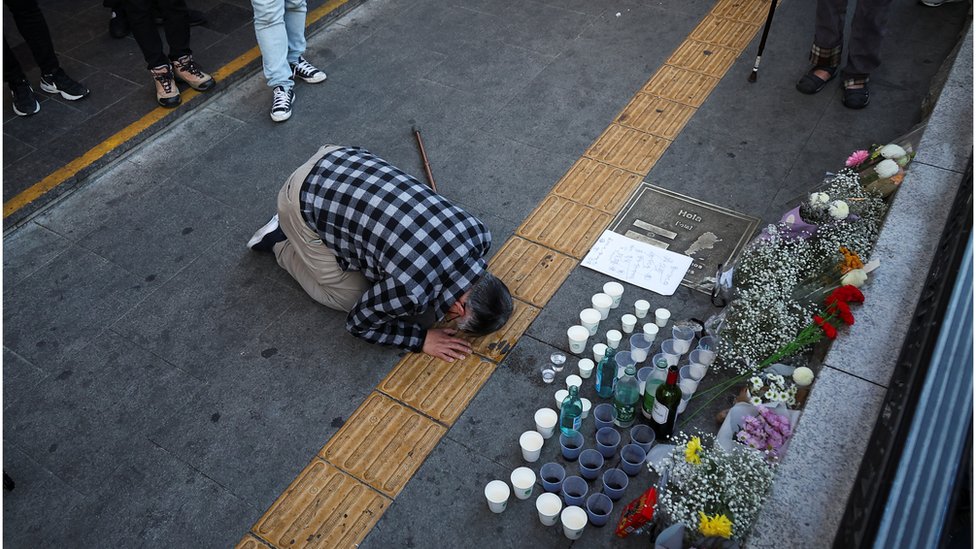 A person pays tribute to victims near the site of a stampede during Halloween celebrations in Seoul.