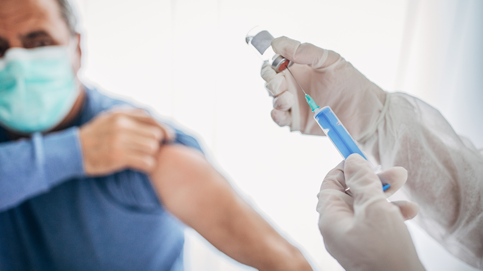 Vacina sendo preparada para ser aplicada em homem