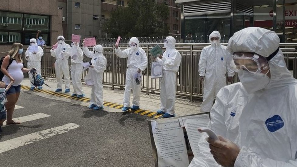 Trabajadores en Pekín con material protector.