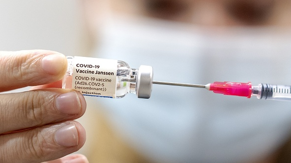 Profissional de saúde segura ampola de vacina e agulha